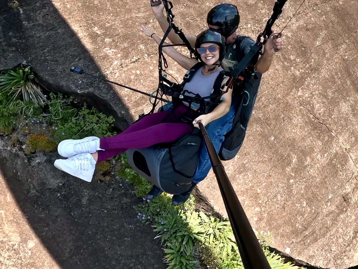 Passageira sorrindo logo após decolar da rampa de parapente da Pedra Bonita
